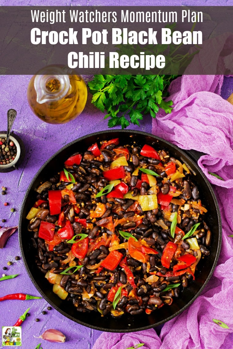 Overhead shot of a bloack bowl of Crock-Pot Black Bean Chili on a purple tablecloth and tabletop.