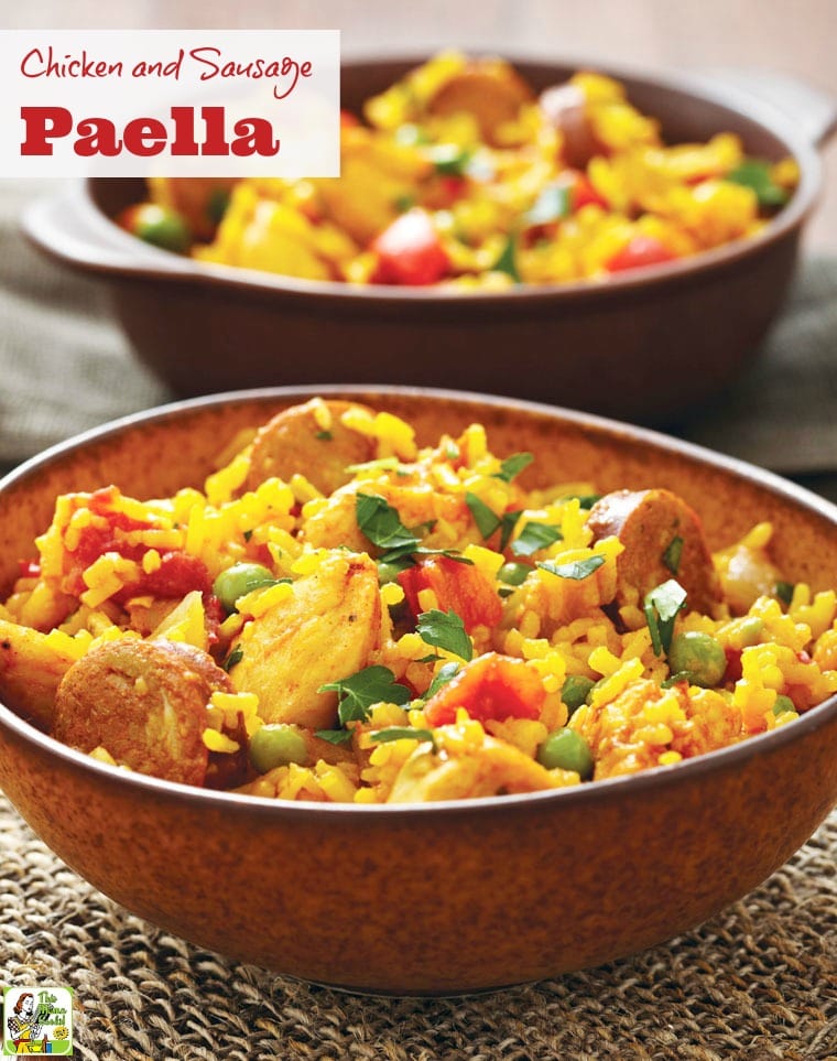 Closeup of a bowl of chicken and sausage paella on a woven mat.