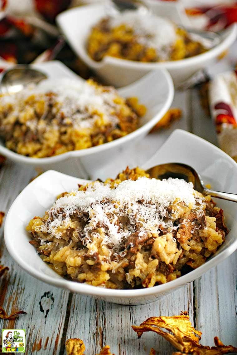 Closeup of a bowls of wild mushroom risotto topped with cheese.