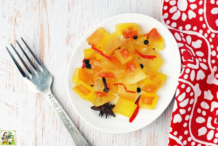 A plate of crisp pickled watermelon rind with red and white napkin and fork.