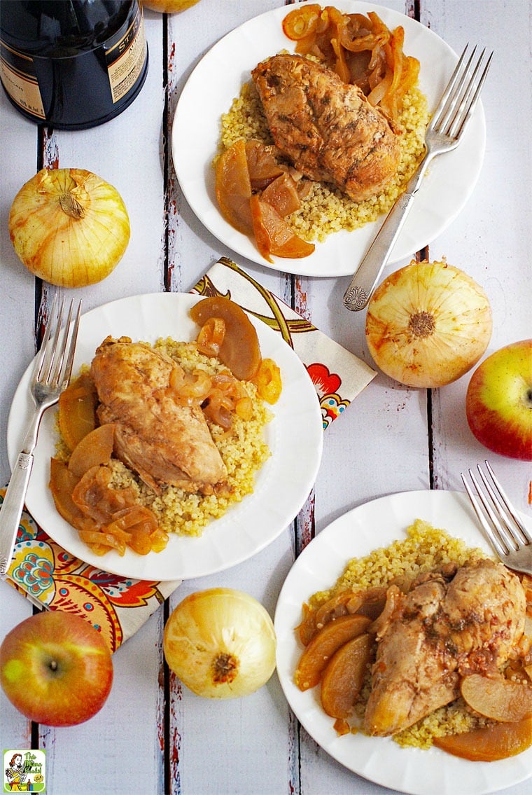 White plates of Chicken Normandy served on quinoa. With forks and floral napkins. 