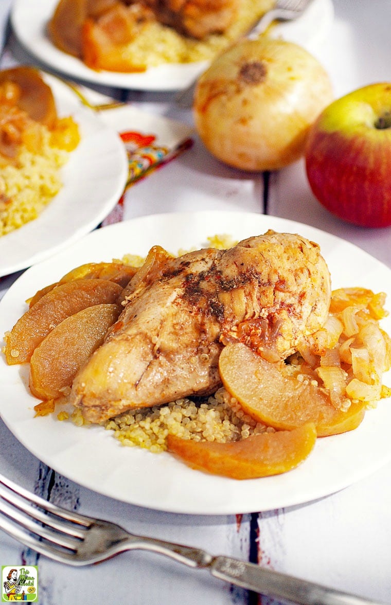 Plate of Chicken Normandy with apples and onions served on quinoa with fork. 