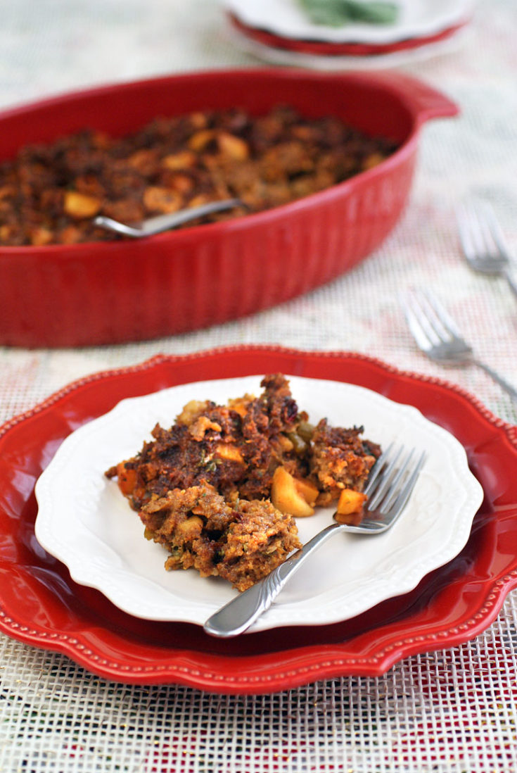 A holiday plate and casserole dish of Gluten Free Cornbread Stuffing with Chorizo, Squash & Apples.