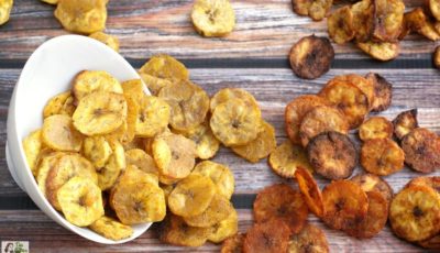 Baked plantain chips spilling out of a white bowl