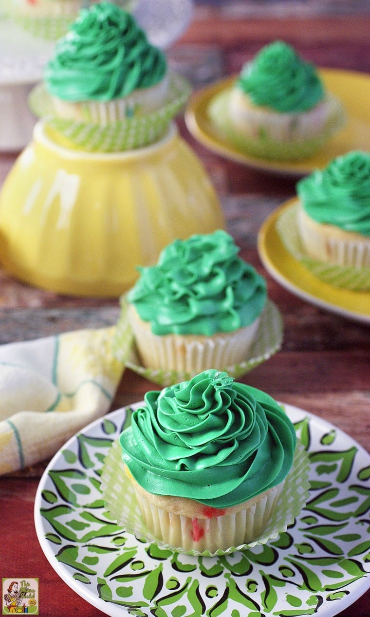 Cupcakes with green frosting on green and yellow plates. 