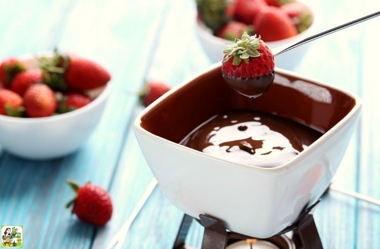 Dipping a strawberry into a pot of Dairy Free Chocolate Fondue.