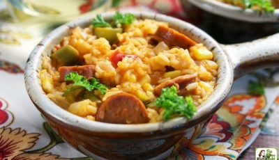 A lug bowl of One Pot Andouille Sausage Jambalaya on a colorful floral napkin.