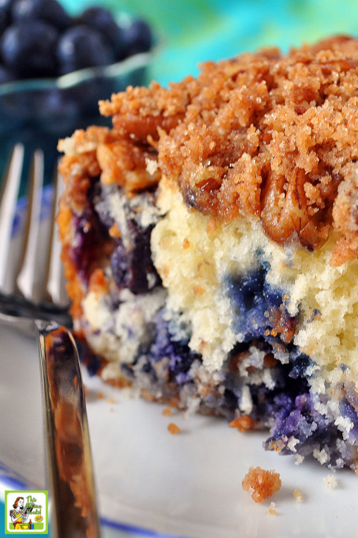 A slice of Blueberry Muffin Streusel Cake on a white plate with fork.