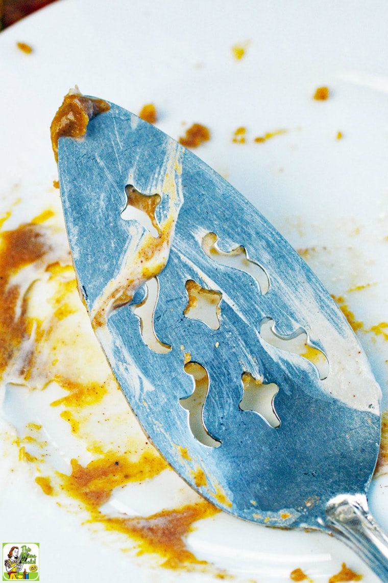 A serving knife with whipped cream and pumpkin pie.