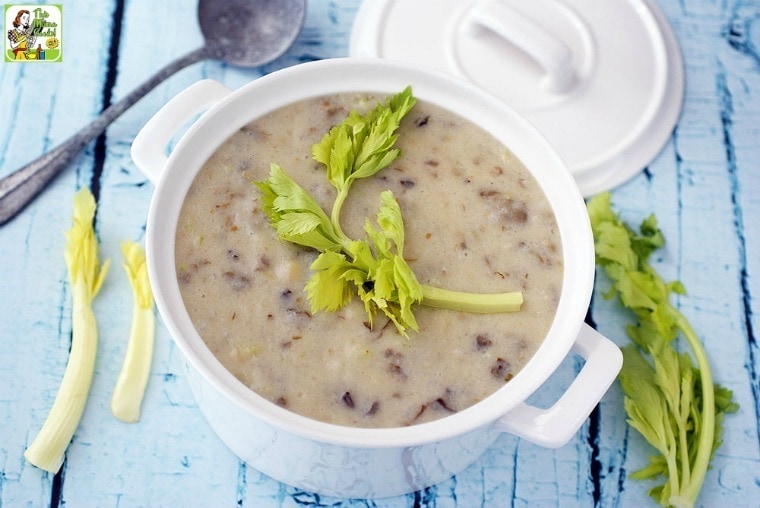 A bowl of Easy Dairy Free Oyster Chowder with lid, celery stalks, and ladle.