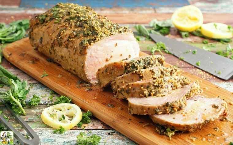 Herb & Lemon Pork Loin Marinade Roast on a wooden cutting board.