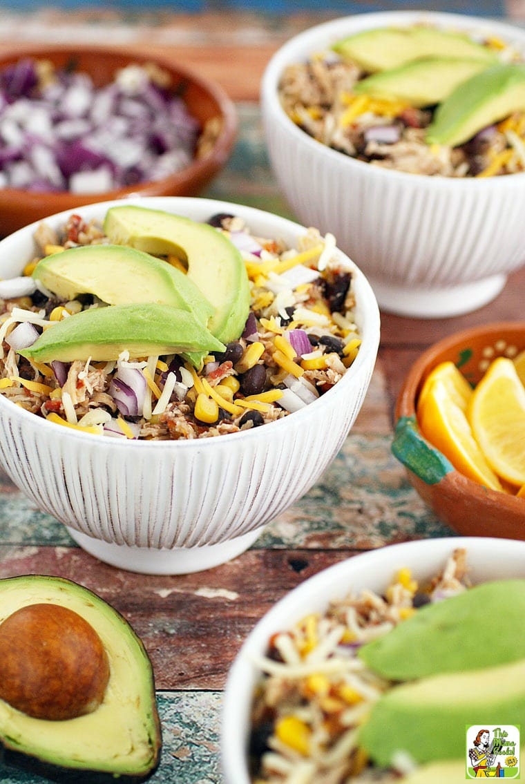 White Bowls of Mexican Shredded Chicken with beans, cheese, onions, and avocados