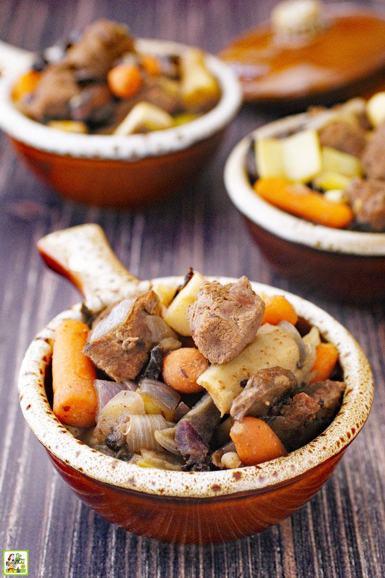 Bowls of the best slow cooker venison stew filled with carrots, parsnips, onions, and mushrooms.