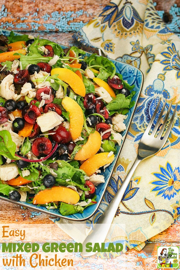 Mixed green salad with chicken with fork and floral napkin.