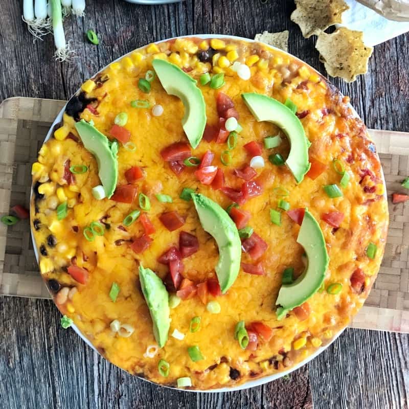 A bowl of Best Bean Dip Recipe with avocado slices.