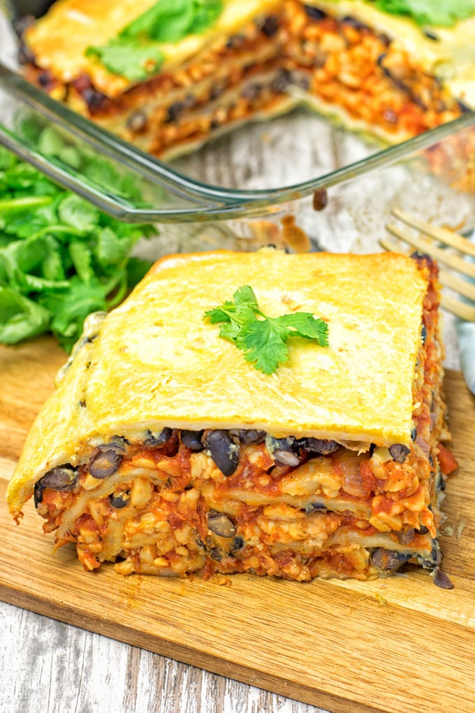 A slice of Easy Vegan Taco Lasagna on a wooden board.