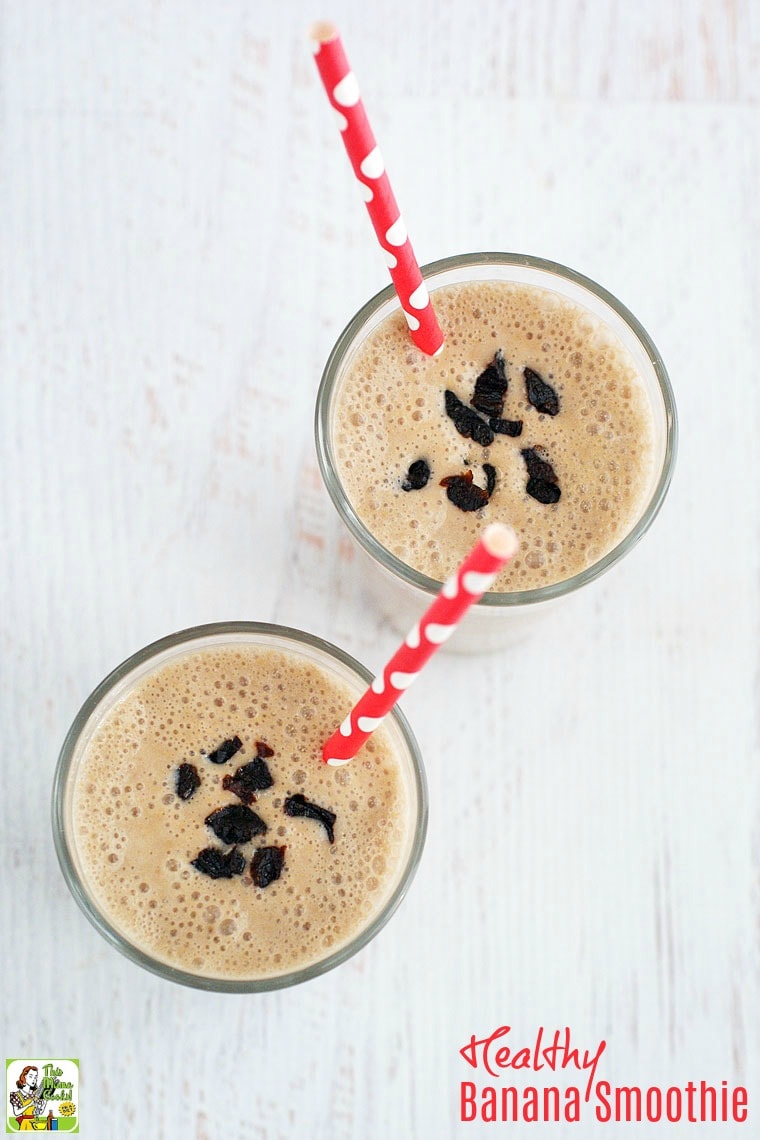 Overhead shot of two glasses of banana smoothie with red straws.