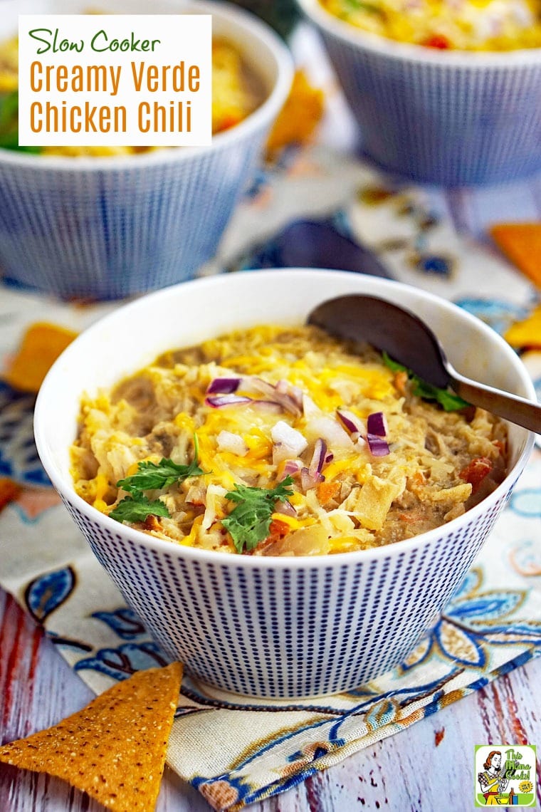 Bowls of Slow Cooker Creamy Verde Chicken Chili with spoon and tortilla chip.