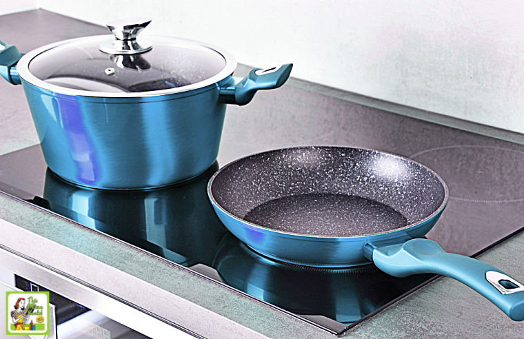 Blue non-stick pot and pan on an induction cooktop stove.