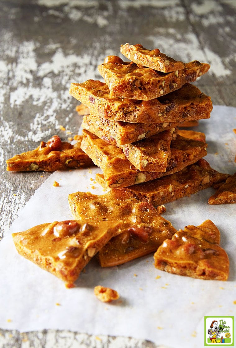 A pile of microwave brittle on white parchment paper.