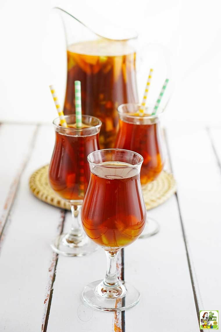 Tall glasses and a pitcher of iced tea infused tea on a straw mat.