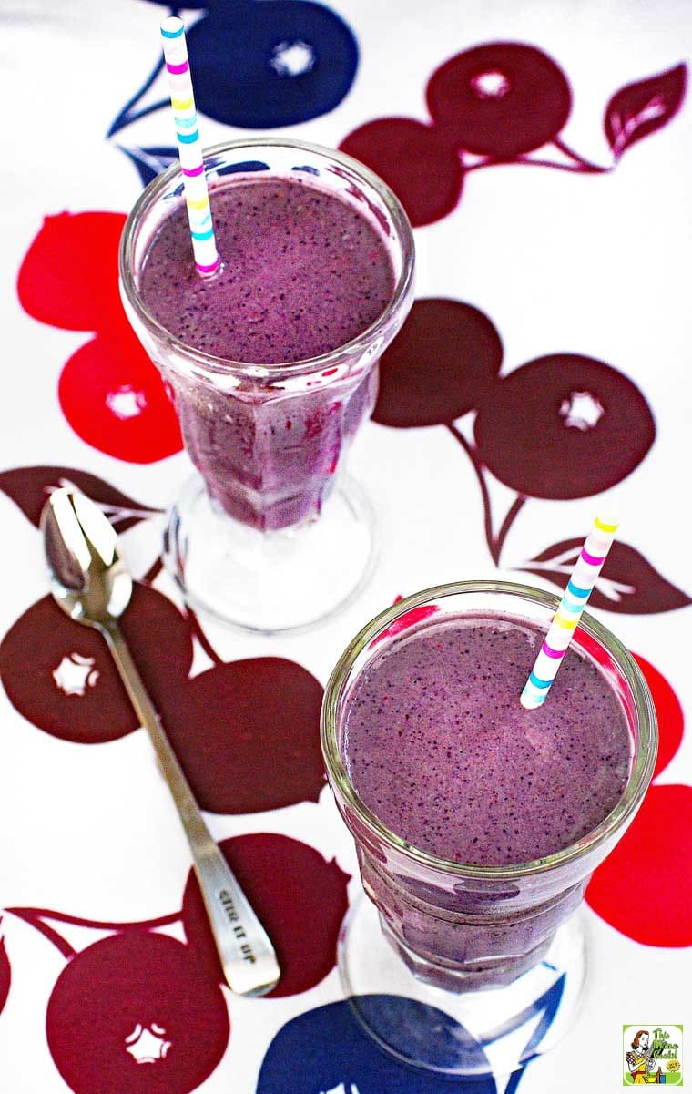 Berry smoothies in milk shake glasses with striped straws.