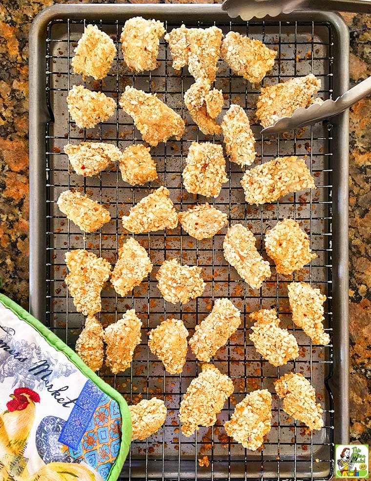 A baking tray of Homemade Chicken Nuggets with pot holder.