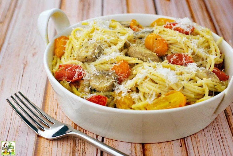 A bowl of Crab Pasta with Pesto, Mushrooms & Tomatoes and fork.