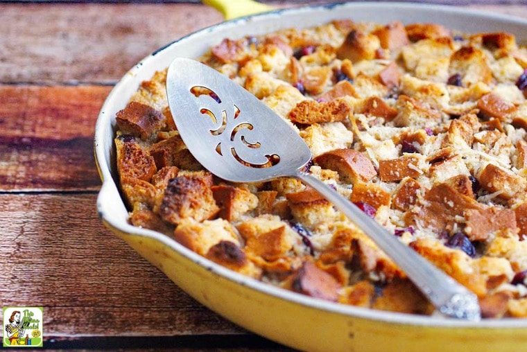 Bread Pudding with Whiskey Sauce in a yellow skillet with a serving knife.