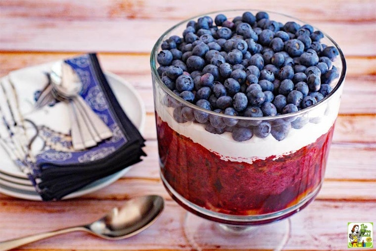 Red White and Blue Trifle in a trifle bowl with serving spoon, plates, napkins, and spoons.