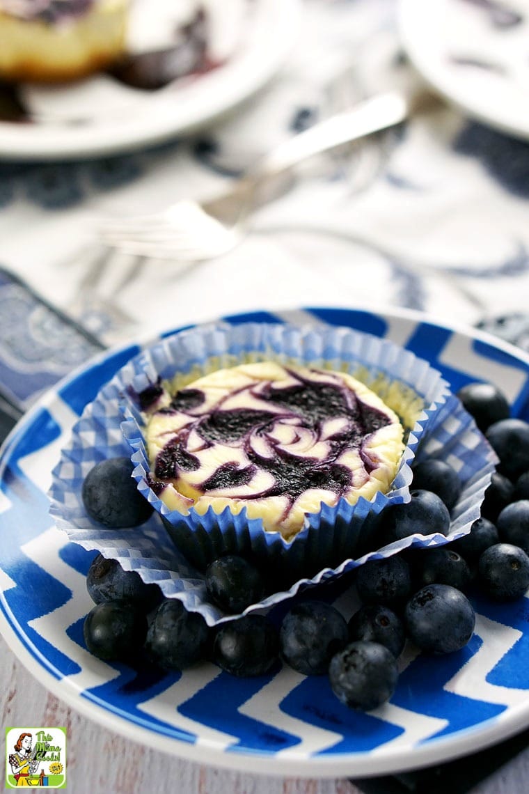 A small blue plate with mini cheesecake and blueberries.