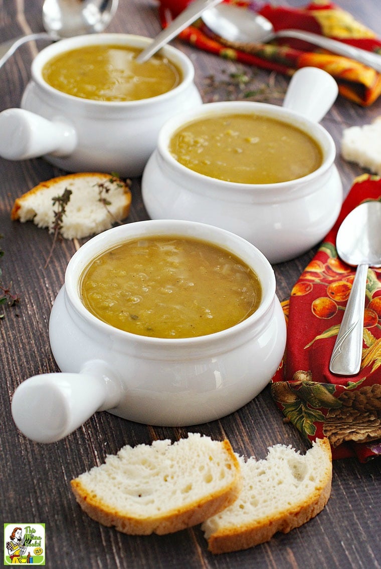 Split pea soup in white soup bowls, spoons, bread, and red napkins.