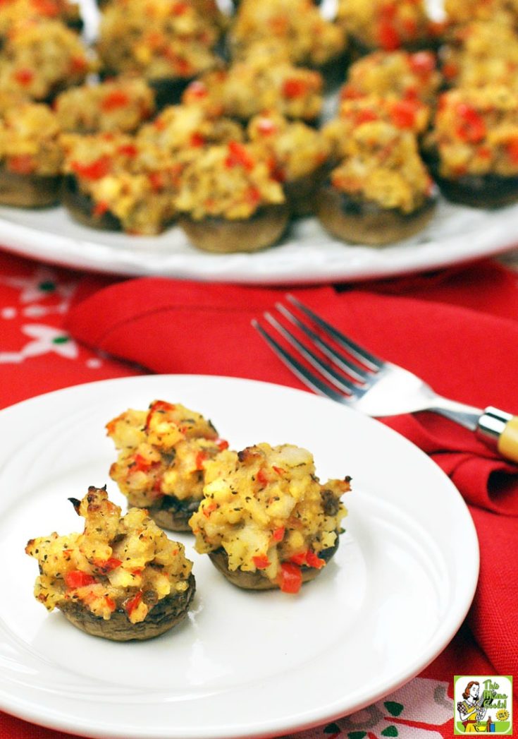Several stuffed mushrooms on a white plates with fork.