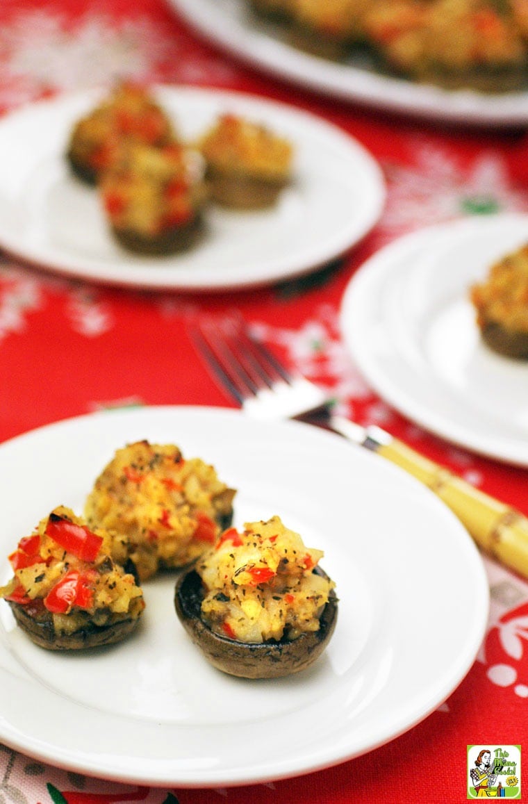 Several stuffed mushrooms on a white plates with fork.