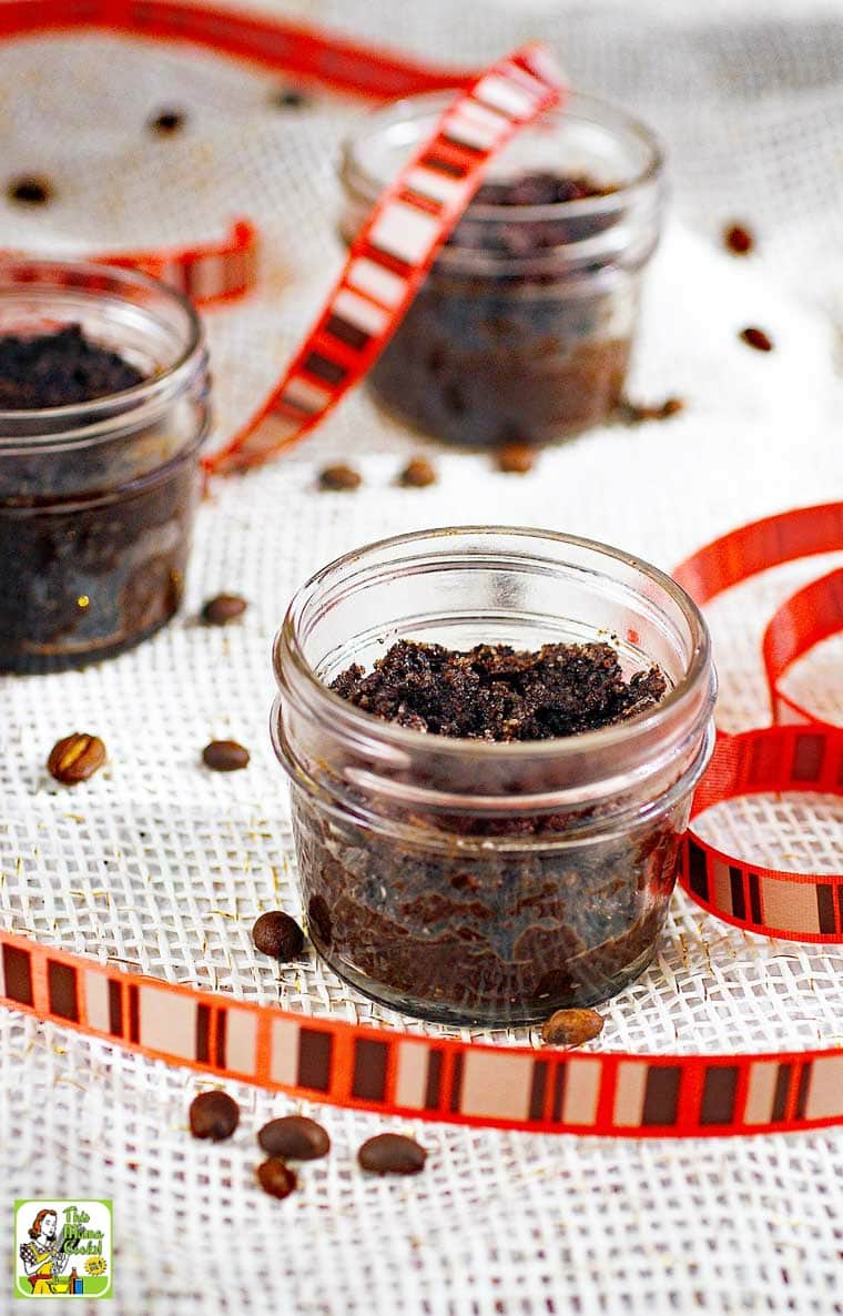 Jars of homemade coffee sugar scrub with striped ribbon and coffee beans.