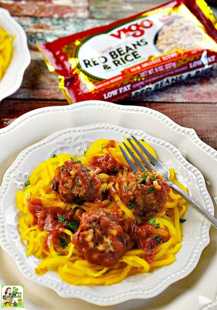 A white plate of meatballs served on squahs noodles and package of Vigo Red Beans and Rice.