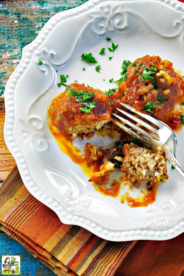 Overhead of a plate of porcupine meatballs with a fork, parsley, and napkin.