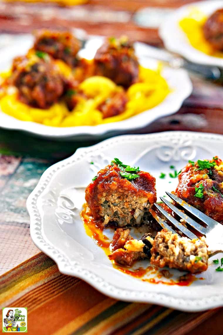 Overhead of a plate of porcupine meatballs with a fork, parsley and napkin and another plate of slow cooker porcupine meatballs served on butternut squash zoodles.