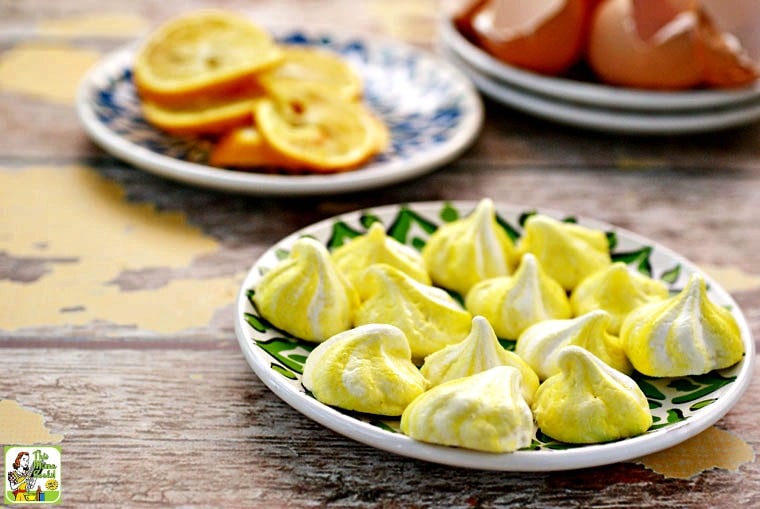 A small plate of many yellow and white meringue cookies.