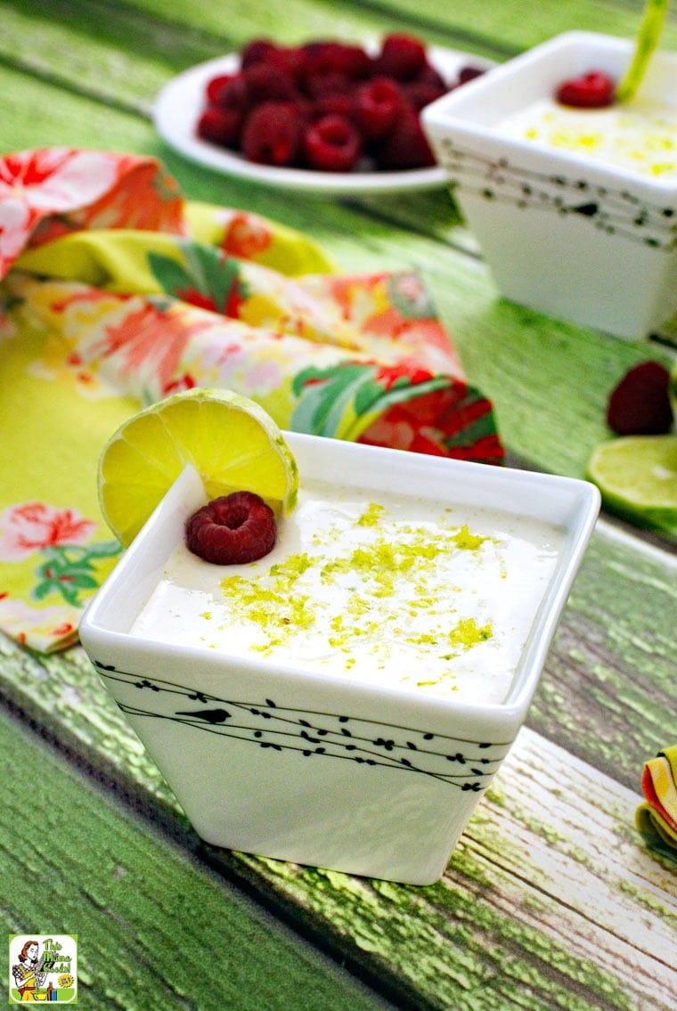 Bowls of Key Lime Mousse garnished with lime and a raspberries with floral napkins.