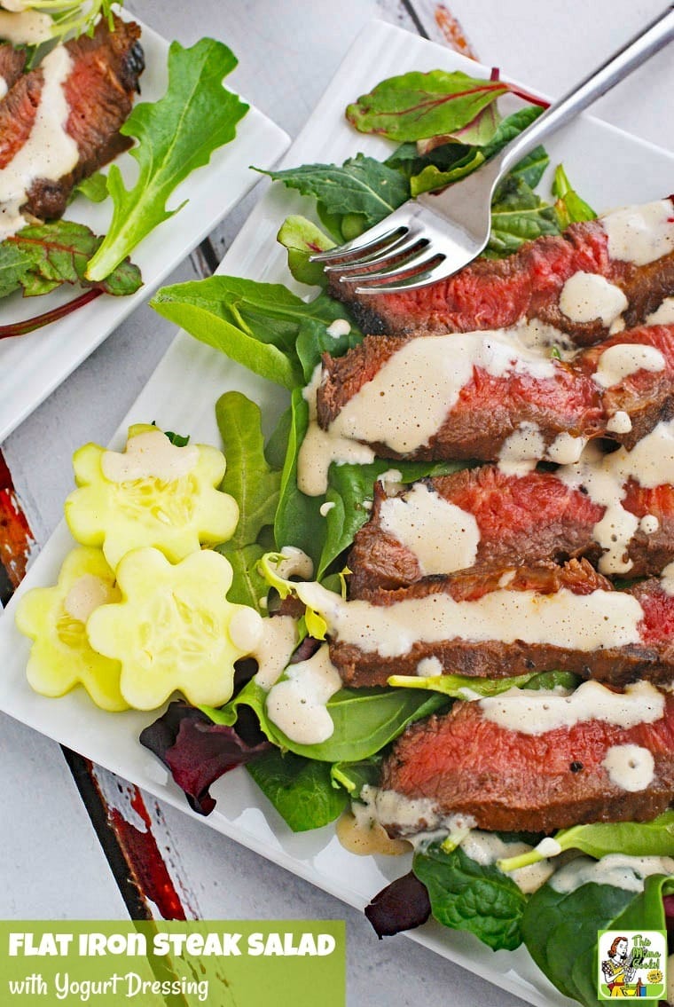 Closeup of a plate of Flat Iron Steak Salad with Yogurt Dressing with salad and tomatoes.