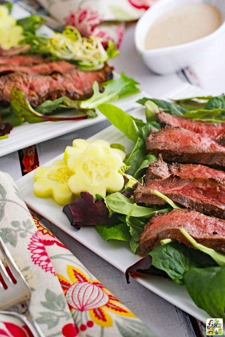 Closeup of Flat Iron Steak Salad with Yogurt Dressing with napkin and fork.