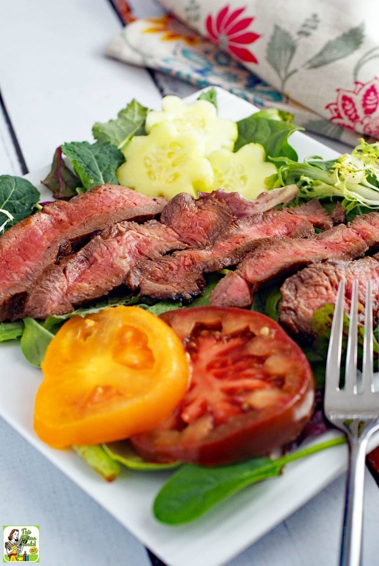 Closeup of Flat Iron Steak Salad with Yogurt Dressing with sliced tomatoes and fork.