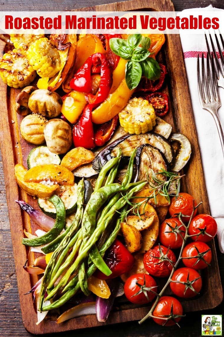 A wooden platter of Roasted Marinated Vegetables with serving fork.