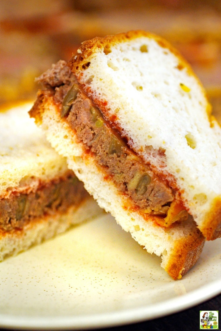 Closeup of a stack of meatloaf sandwiches on a white plate.