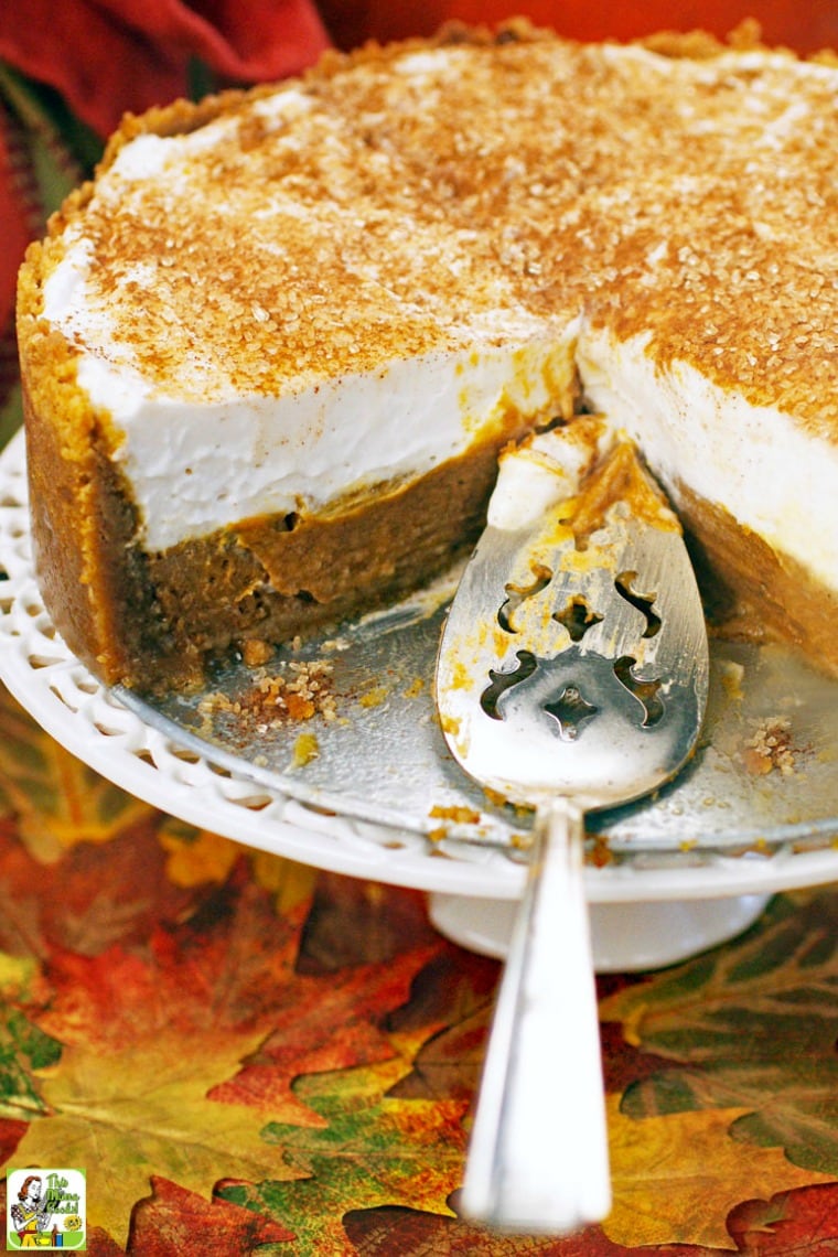A cake stand and serving spoon with a deep dish pumpkin pie.