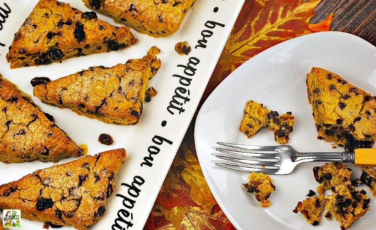 A plate and plate of gluten free scones with pumpkin, raisins, and chocolate chips.