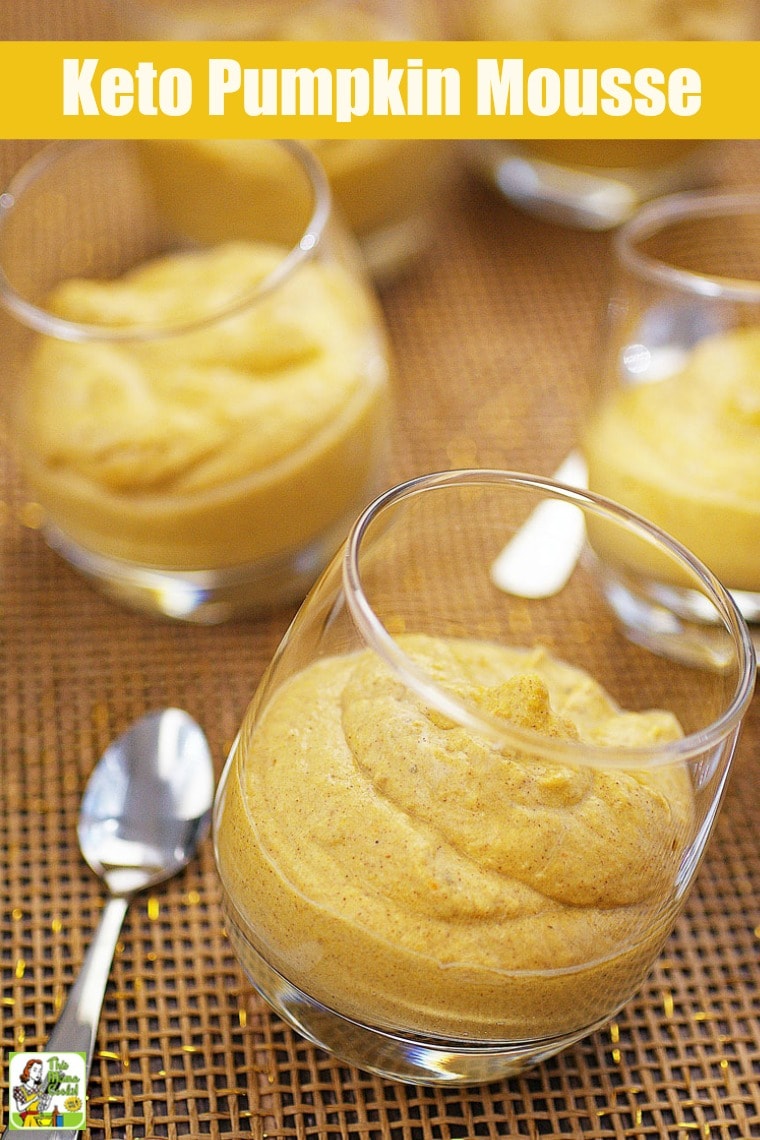 Closeup of a glass of creamy pumpkin mousse with a silver spoon.
