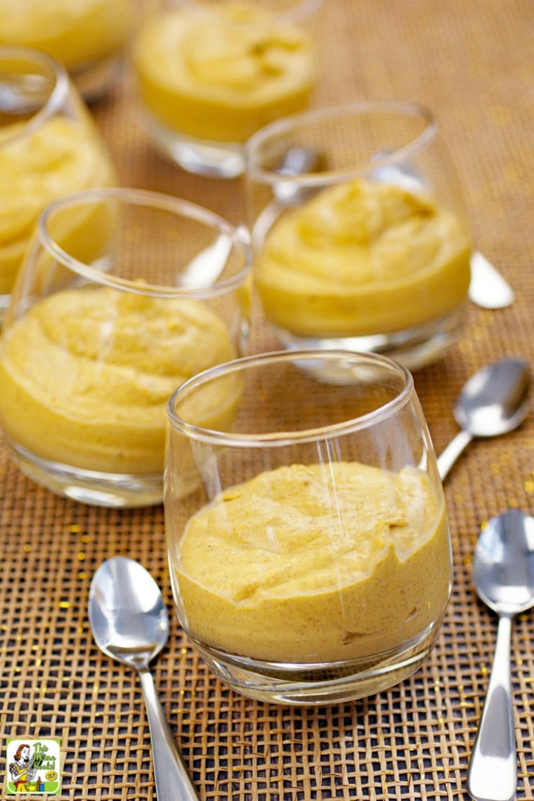Glasses of pumpkin pie mousse with small spoons.