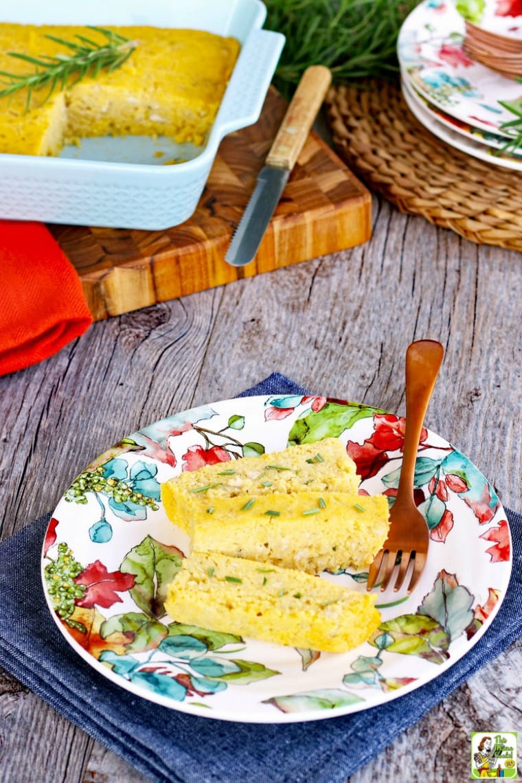 A baking dish of vegan cornbread and a slice of cornbread on a colorful plate with a copper fork.